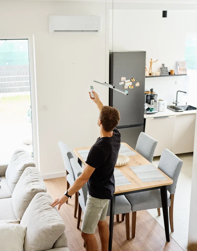 Man adjusting air con with remote